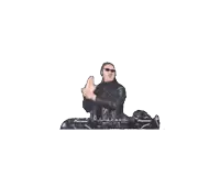a man in a leather jacket and sunglasses is holding a pillow while sitting on a table .