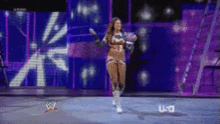 a woman is dancing on a stage in front of a screen that says u-c