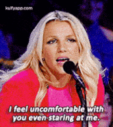 britney spears is singing into a microphone and saying `` i feel uncomfortable with you even staring at me '' .
