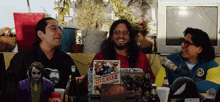 a group of men are sitting around a table with a comic book titled civil war ii