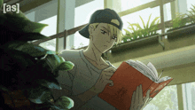 a boy in a baseball cap is reading a book with the word [ as ] on the bottom