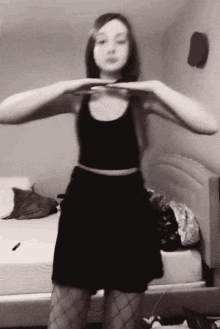 a woman in a black dress and fishnet stockings is dancing