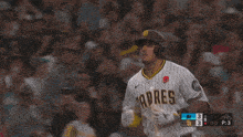 a baseball player wearing a padres uniform runs towards the crowd