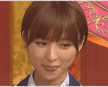 a close up of a woman 's face with a pink background behind her .