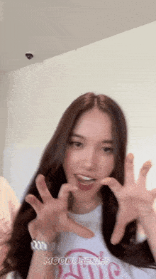 a woman with long hair is wearing a white shirt that says ' mooduseries ' on it