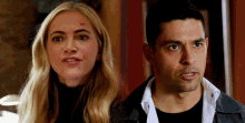 a man and a woman are standing next to each other and the woman has a scar on her forehead