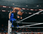 two wrestlers in a wrestling ring with the word raw behind them