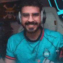 a man wearing headphones and glasses is holding a red box in front of his mouth .