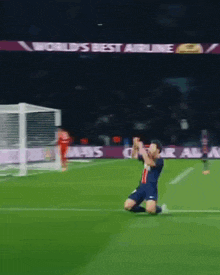 a soccer player is kneeling on the field in front of an advertisement for qatar airways