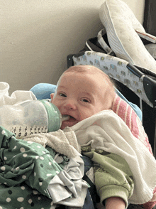 a baby is drinking from a bottle that says 0-6 months