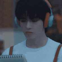 a young man wearing headphones is standing in a dark room .