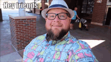 a man wearing a hat and glasses is smiling with the words hey friends above him