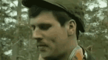 a close up of a man in a military uniform with a mustache wearing a hat .