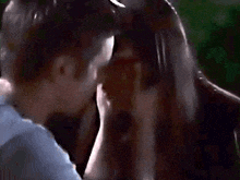 a man and woman are kissing in a dark room .