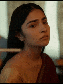 a close up of a woman 's face with a necklace on her neck
