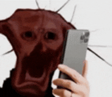 a person is taking a selfie with a cell phone with a red face on it .