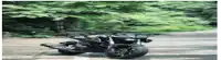 a motorcycle is driving down a road next to a tree .
