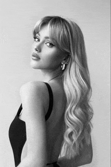 a black and white photo of a woman in a black tank top
