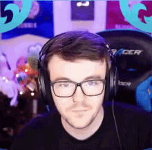 a man wearing glasses and headphones is sitting in front of a chair that says racer