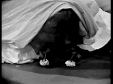 a black and white photo of a person laying on a bed .
