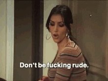 a woman in a striped shirt is standing in front of a door and saying `` don 't be fucking rude '' .
