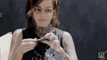 a woman with a lot of tattoos on her body is smoking a cigarette