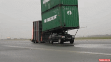 a jeep is being towed by a stack of shipping containers that say gigas