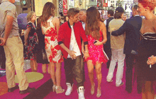 a man in a red jacket is kissing a woman on the cheek