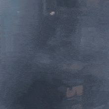 a man in a blue shirt is making a funny face while looking at the camera .