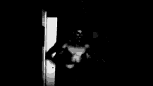 a man without a shirt is standing in the dark with his eyes closed .