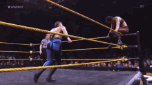 a man in a wrestling ring with the words #wwe nxt behind him