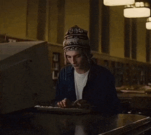 a person wearing a hat is typing on a keyboard
