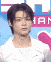 a close up of a young man 's face in front of a pink and blue background .