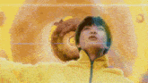 a woman in a yellow jacket is looking up at a giant donut
