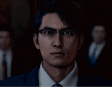 a man wearing glasses and a suit is looking at something