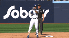 a blue jays baseball player getting ready to bat in front of a sobers sign