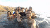 a group of people are swimming in the water and one of them is wearing a shirt that says under armour
