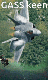 a fighter jet is flying over a field with the words gass keen written on it .