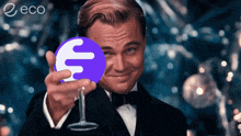 a man in a tuxedo is holding a wine glass in front of a purple circle with a letter f on it