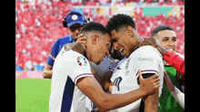 two soccer players hugging each other on the field .
