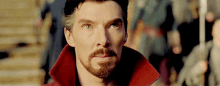 a close up of a man with a beard and a red coat