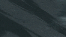 a man in a black and white suit is laying on the ground holding a sword