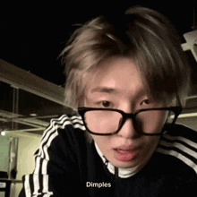 a close up of a person wearing glasses with the word dimples visible