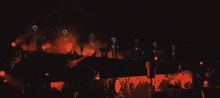 a group of people standing on a stage with red lights