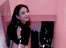 a woman is standing in a pink room and smiling