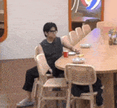 a man is sitting at a table with a cup of coffee and a plate of food .