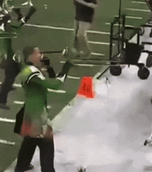 a man in a green jacket is standing in front of a red cone that says 40