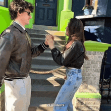 a man and a woman giving each other a high five in front of a green building