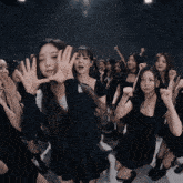 a group of young women are dancing in a dark room
