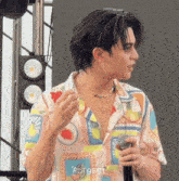 a man holding a microphone and wearing a shirt that says rdt best on it